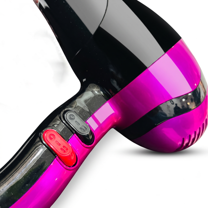 Close-up of a hair dryer with a glossy black body and a bright magenta-pink lower section, featuring red and black power buttons on the handle, set against a plain white background.