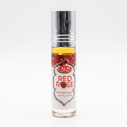 A clear cylindrical roller bottle of AIM Cosmetics Red Rose fragrance oil with a silver cap, showing red rose petals and amber liquid inside, on a white background.